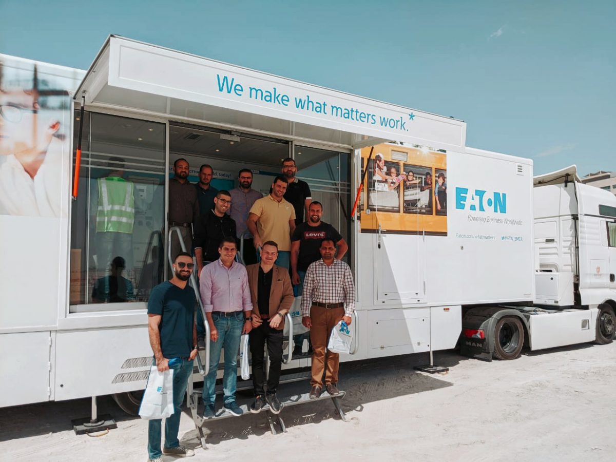 Employees posing in front of the Eaton InfoVAN 06 after a successful training event