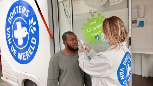 Doctor taking care of patient outside the Dokter van de wereld InfoWheels Promotor