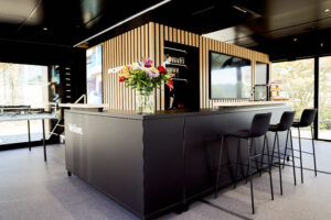 Wood finish with matte black bar and seating inside the Porsche Netherlands Mobile Showroom